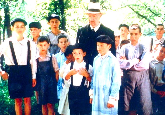 Cena do filme A língua das mariposas que exibe um grupo de crianças com um professor idoso