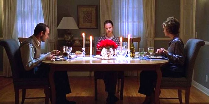 Família de Lester sentada na mesa, jantando.