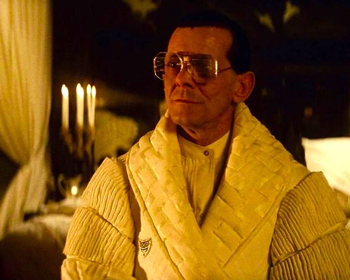 cena amarelada em blade runner exibe Tyrell com roupão e velas ao fundo