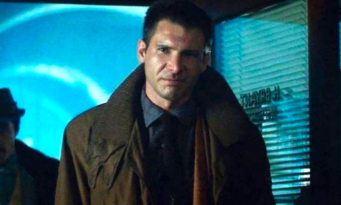 Harisson Ford vive Deckard em blade runner. Ele está de pé com um casaco marrom e atmosfera azulada