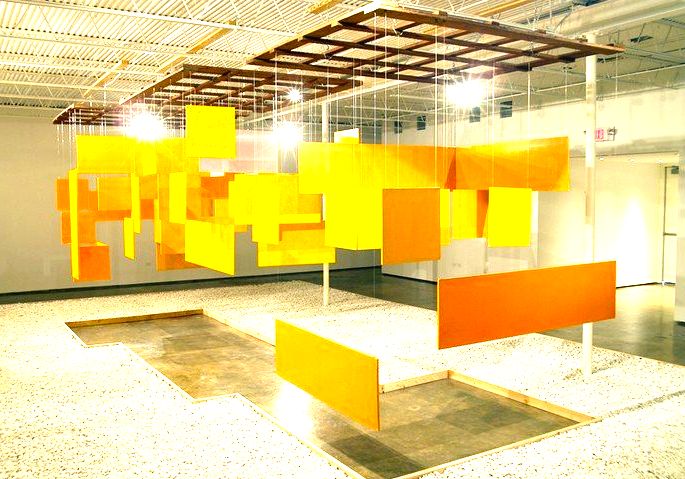 Obra Grande Núcleo, de Helio Oiticica exibe placas de madeira suspensas pintadas de amarelo