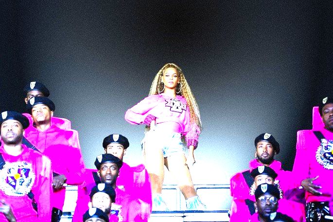 diva pop Beyoncé em cena do filme Homecoming posa com bailarinos em show vestindo roupa rosa