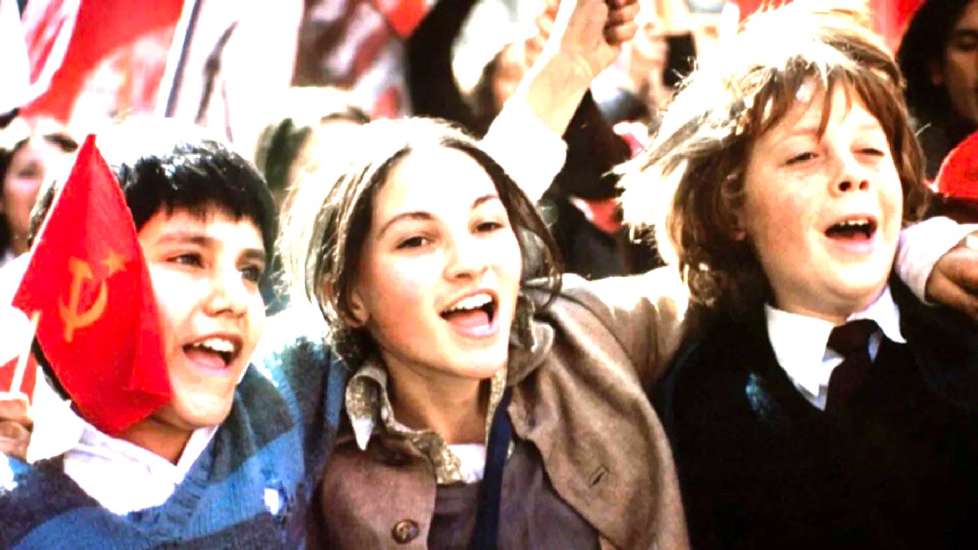 cena do filme Machuca mostra três crianças abraçadas sorrindo