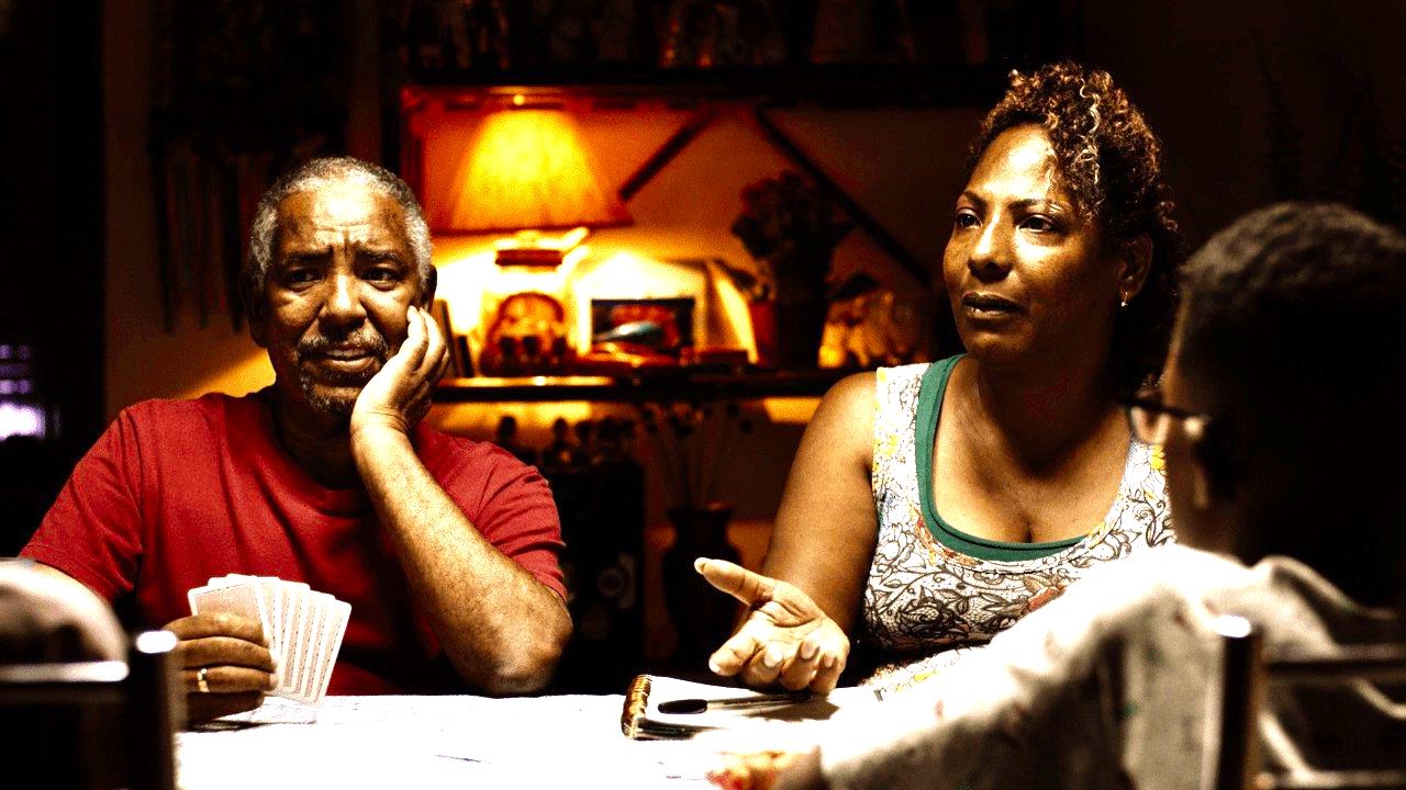 cena do filme Marte Um mostra casal em mesa de jantar conversando e jogando baralho