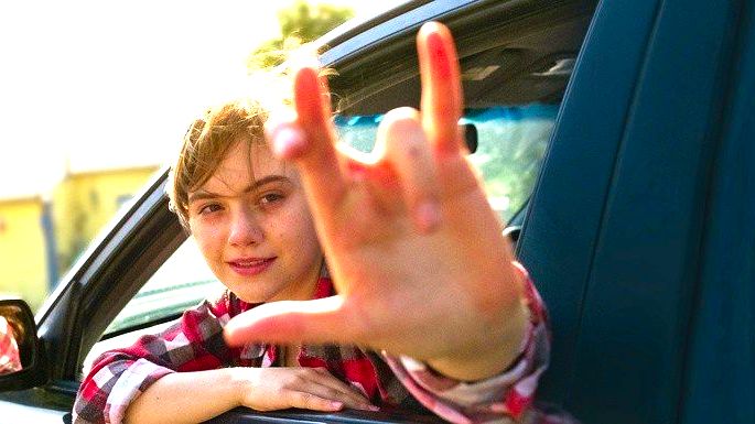 Adolescente na janela do carro, fazendo sinal de língua gestual.