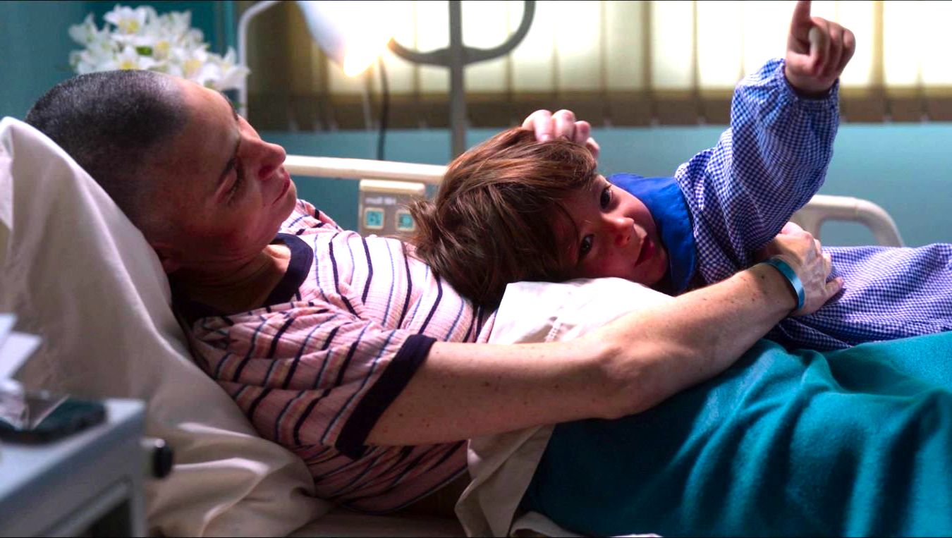 cena de O caderno de Tomy mostra uma mulher e seu filho em um leito de hospital