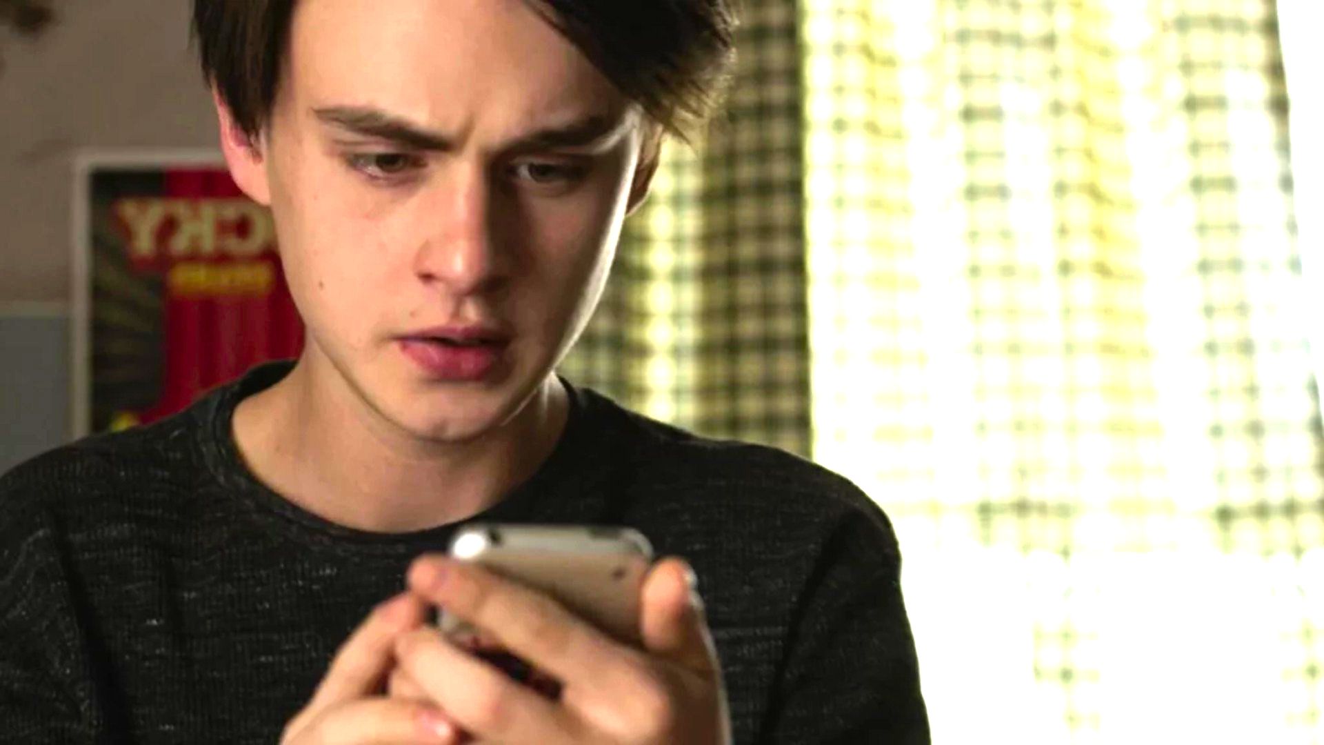 cena do filme O telefone do Sr Harrington mostra jovem olhando o celular