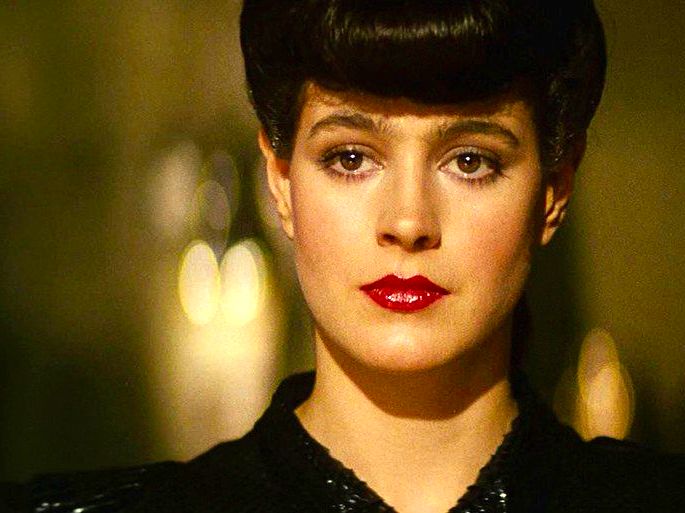 A personagem Racheal em Blade Runner está em fundo amarelado e exibe cabelo preso e olhos avermelhados