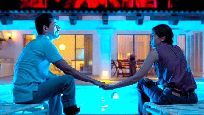 cena de filme Tempo compartilhado exibe um casal a noite à beira da piscina