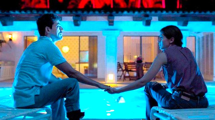 cena de filme Tempo compartilhado exibe um casal a noite à beira da piscina