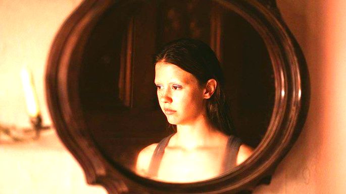 Reflexo de mulher jovem no espelho.